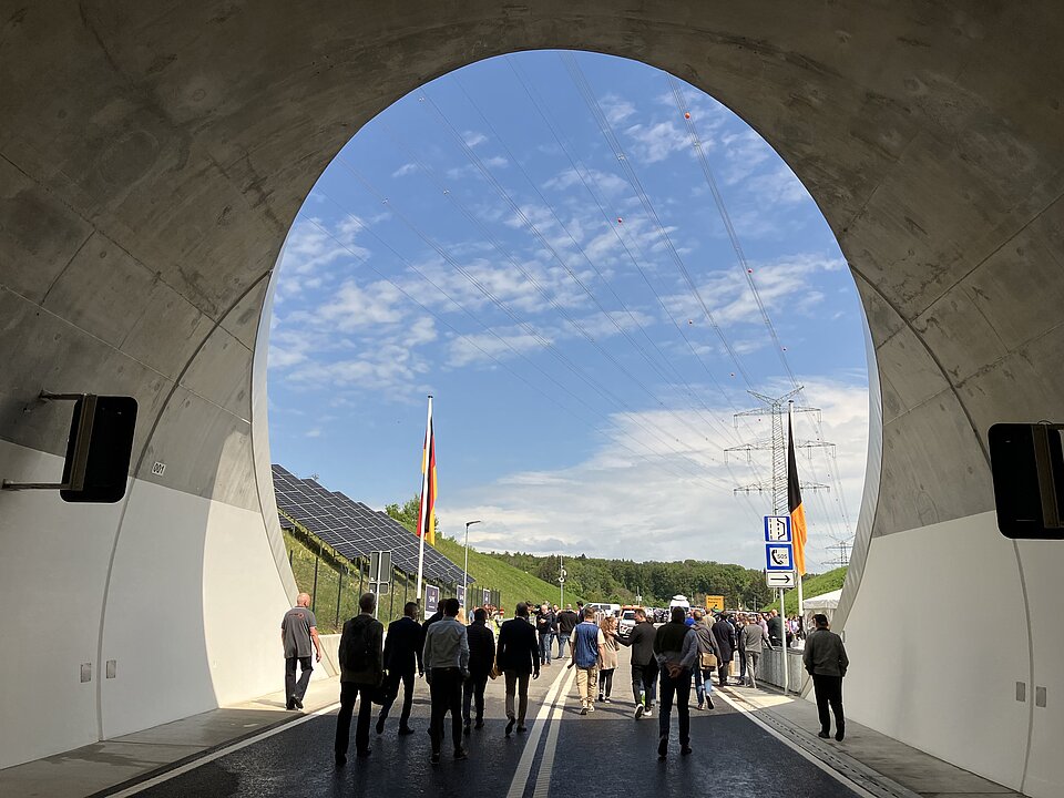 Menschen bei der Eröffnungsfeier laufen aus dem Tunnel