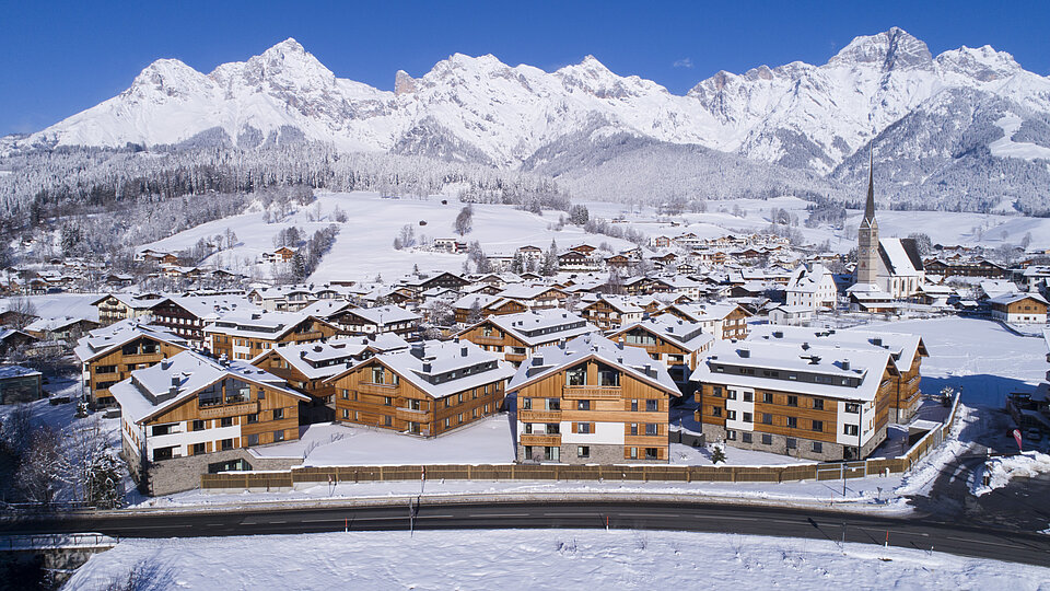 Luftbild vom gesamten AlpinLodges Maria Alm Resort im Winter 